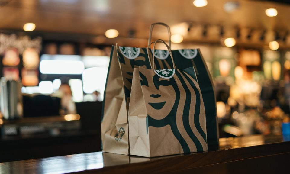 Two carryout bags placed on the counter inside of a Starbucks store.