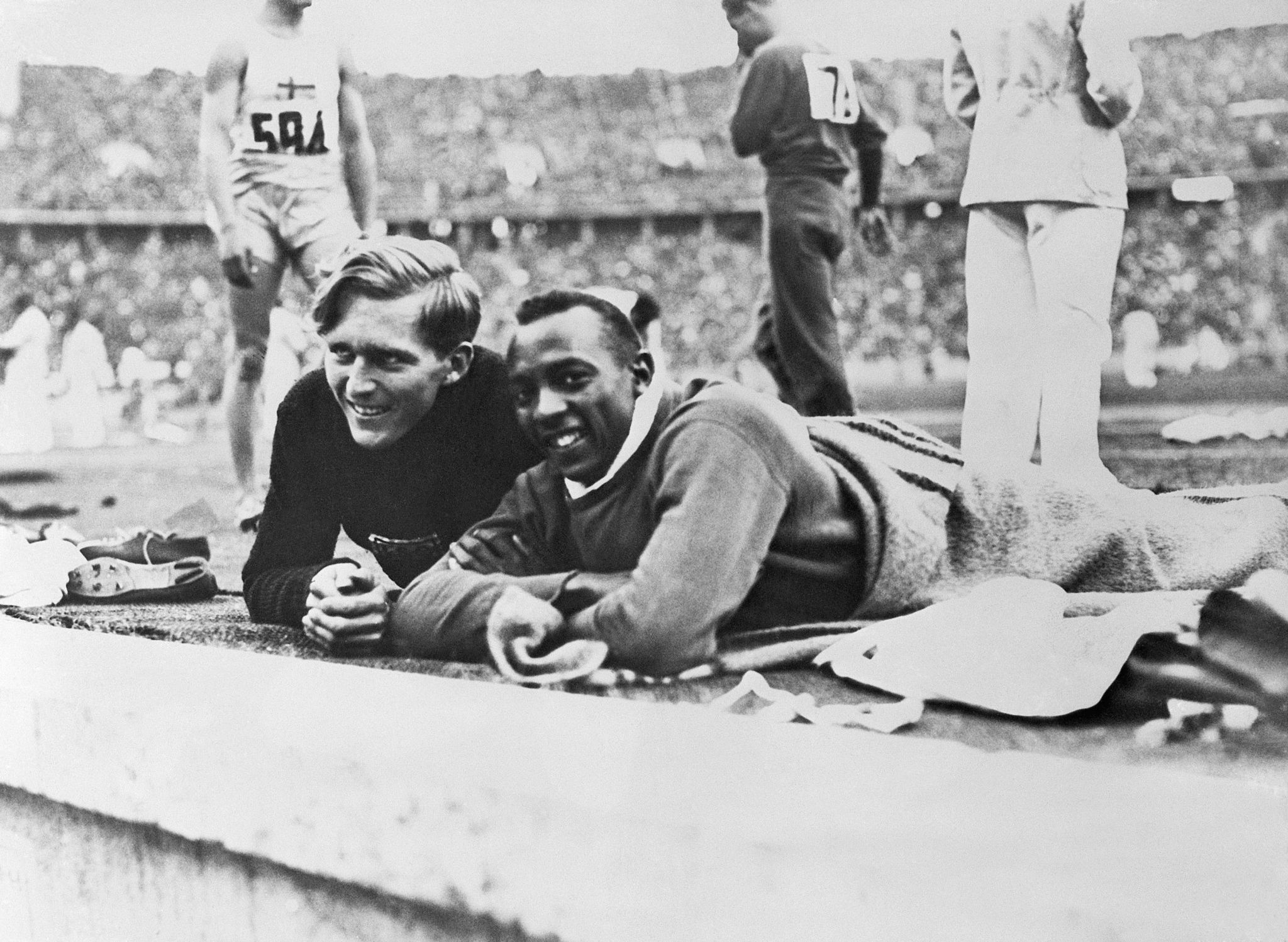 Jesse Owens and Luz Long lie in the Olympic Stadium at Berlin 1936