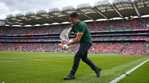 Getty Images Seagull being carried off the pitch by an official