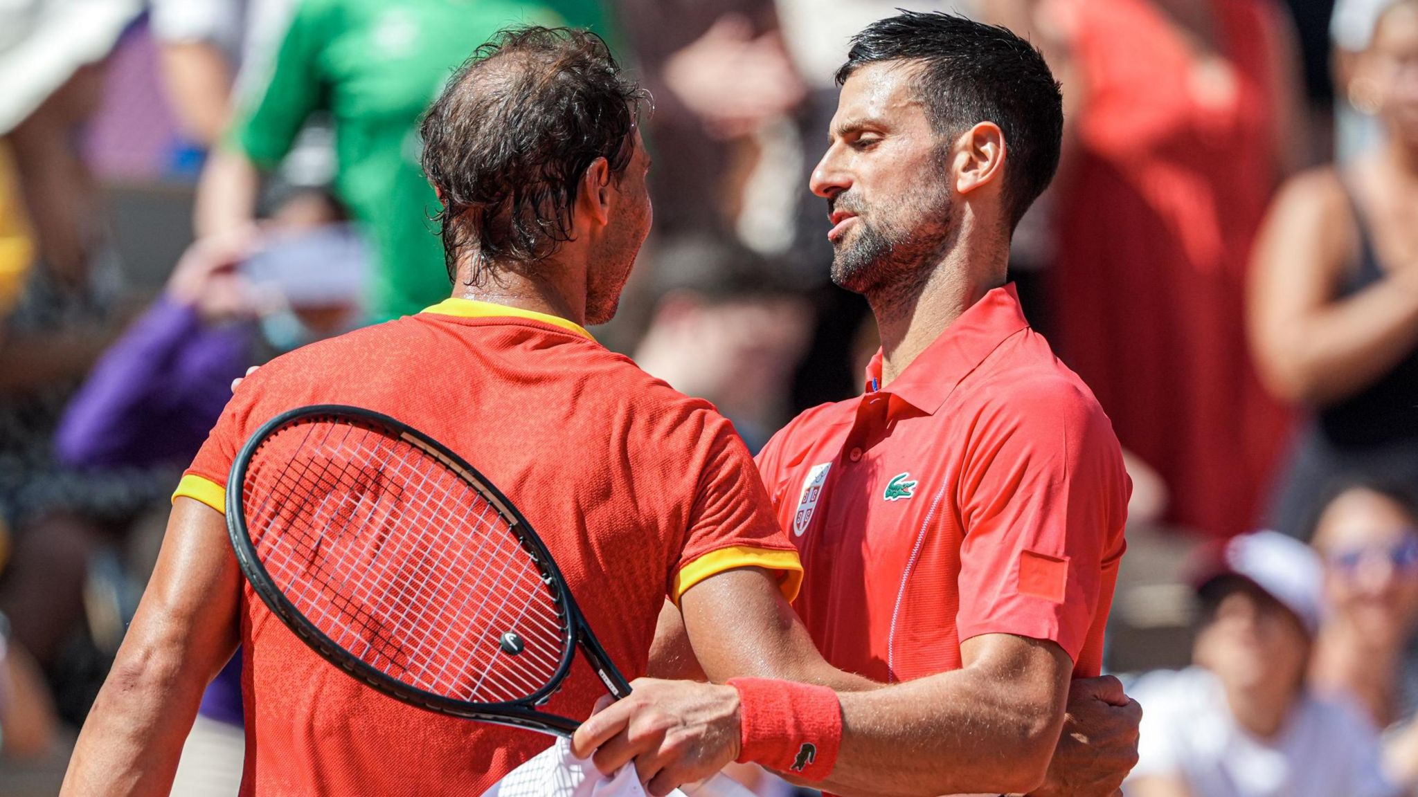 Rafael Nadal and Novak Djokovic embrace at the net