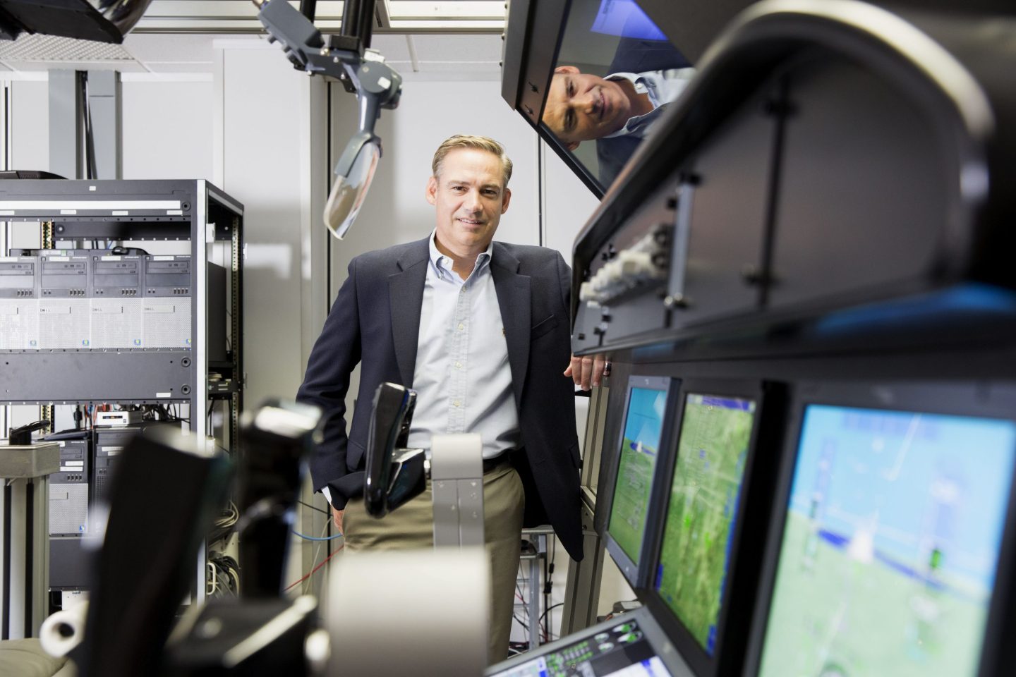 Robert "Kelly" Ortberg stands next to air traffic control hardware