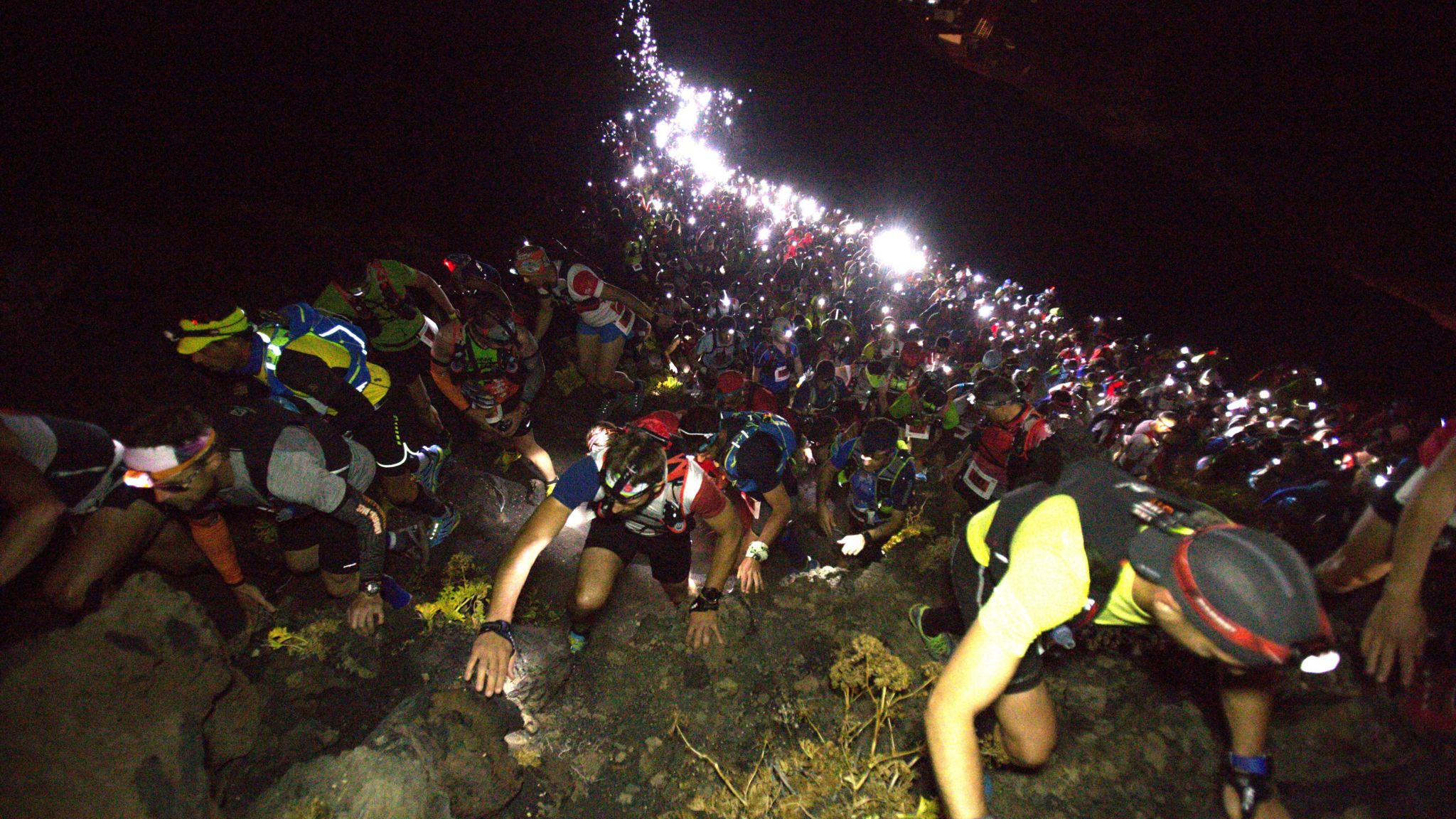 Runners climb a slope at Transvulcania with their headtorches lighting the way