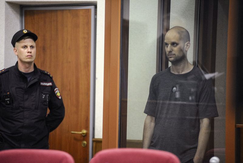 © Reuters. FILE PHOTO: Wall Street Journal reporter Evan Gershkovich, who faces charges of espionage, stands inside an enclosure for defendants as he attends a court hearing in Yekaterinburg, Russia July 19, 2024. REUTERS/Dmitry Chasovitin/File Photo