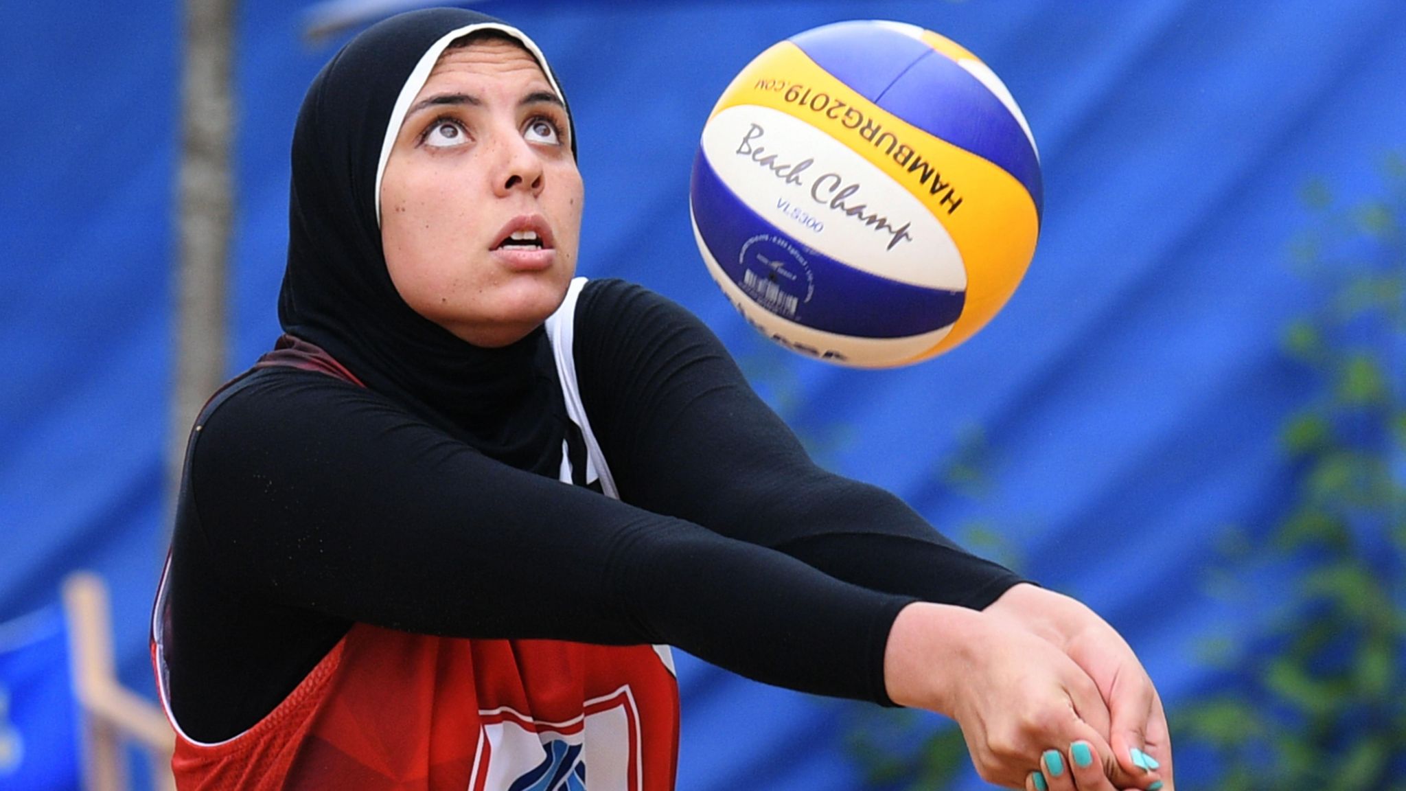 Doaa Elghobashy wears long black sleeves and a headscarf as she plays beach volleyball for Egypt, holding out her arms in front of her as she watches a ball