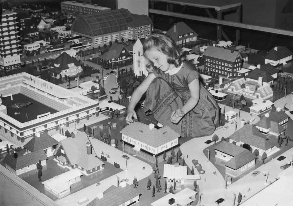 a kid playing with a Lego City set