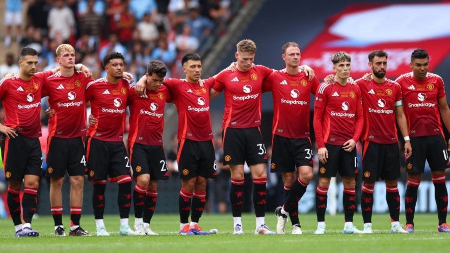 Manchester United players stand arm in arm