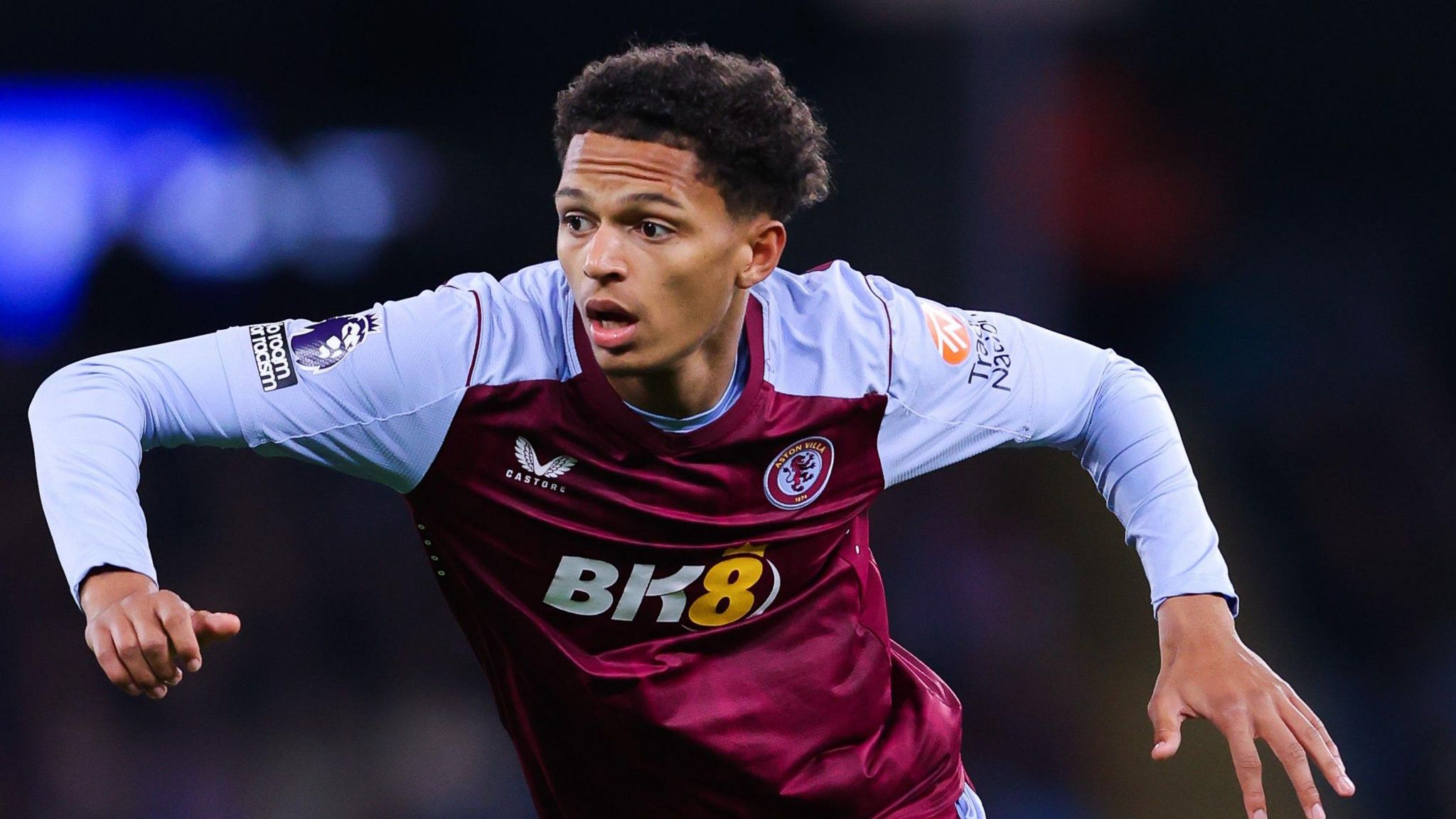 Omari Kellyman spreads his arms and runs while wearing Aston Villa's claret and blue home kit