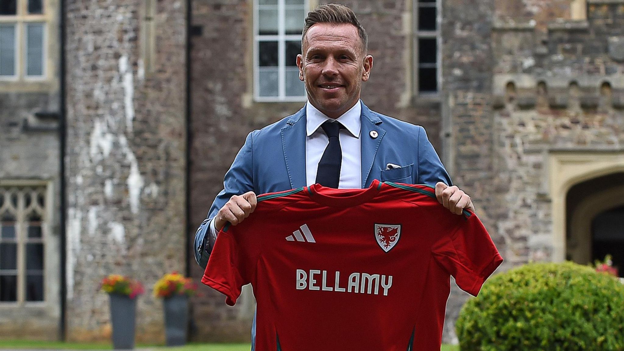 Craig Bellamy holds a Wales shirt