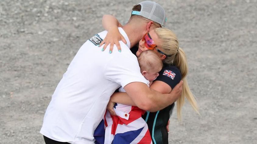 Amber Rutter celebrates skeet shooting silver with husband and baby boy