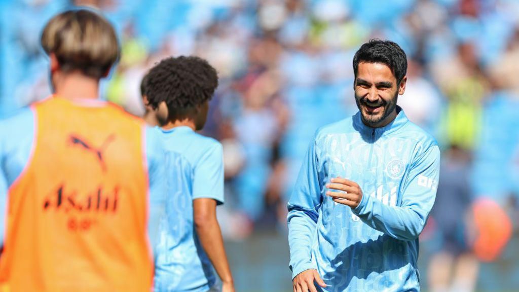 Ilkay Gundogan jokes with his team-mates during warm up for the game against Ipswich