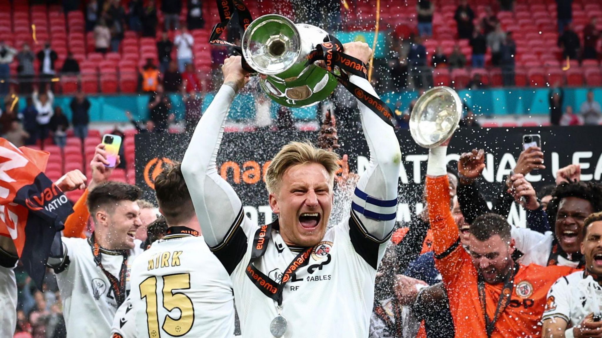 Bromley captain Byron Webster lifts the play-off trophy at Wembley