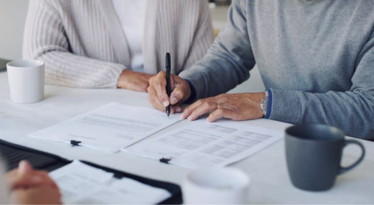 A couple signs a series of documents setting up an irrevocable trust. 