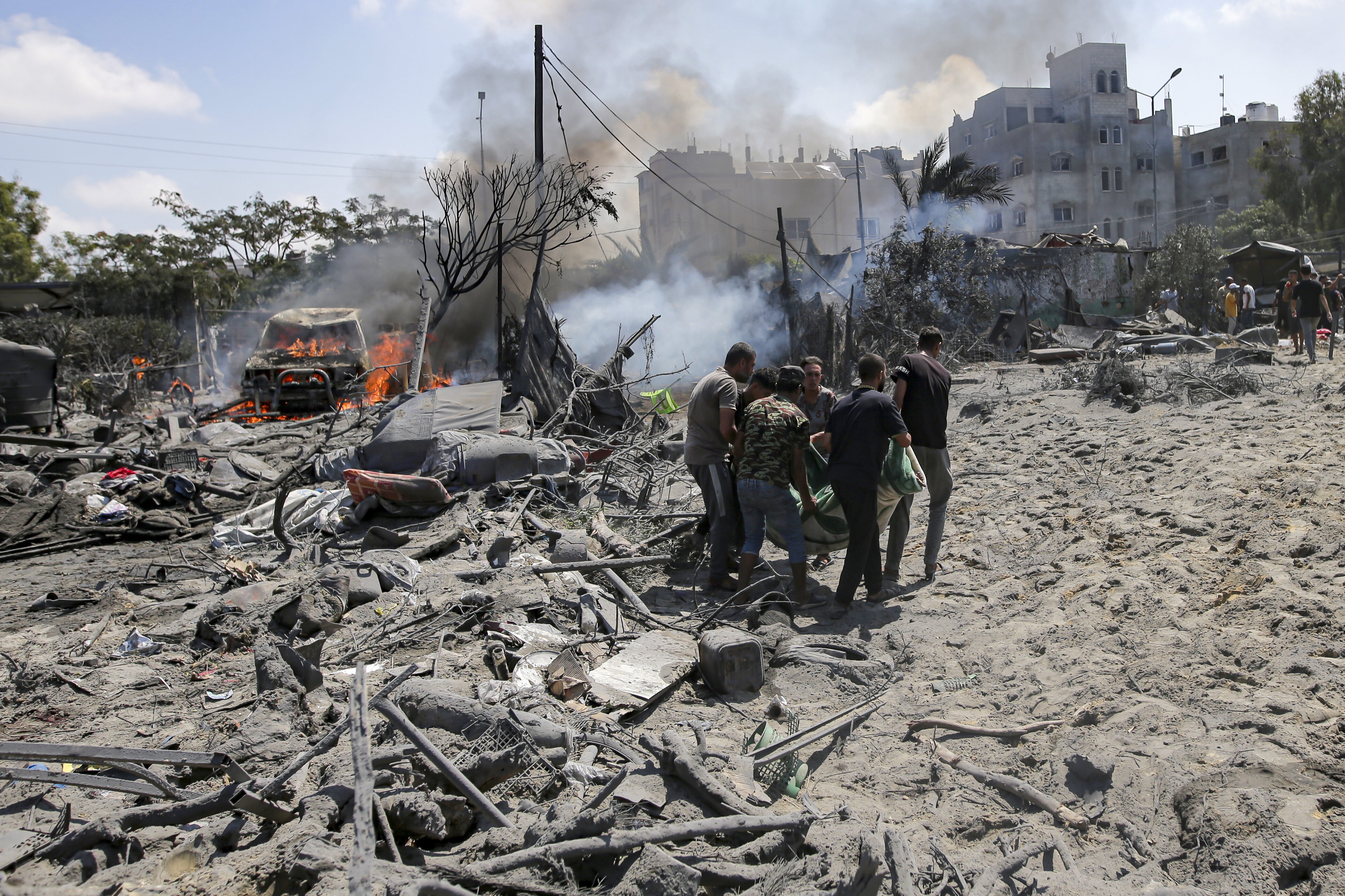 Palestinians evacuate a body from a site hit by an Israeli bombardment on Khan Younis, southern Gaza Strip, on July 13, 2024.