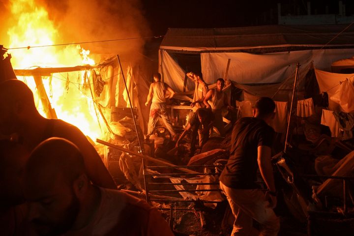 Palestinians react to fire from an Israeli strike that hit a tent area in the courtyard of Al Aqsa Martyrs hospital in Deir al Balah, Gaza Strip, Sunday, Aug. 4, 2024. The strike killed several people including a woman and injured others, health officials confirmed. (AP Photo/Abdel Kareem Hana)