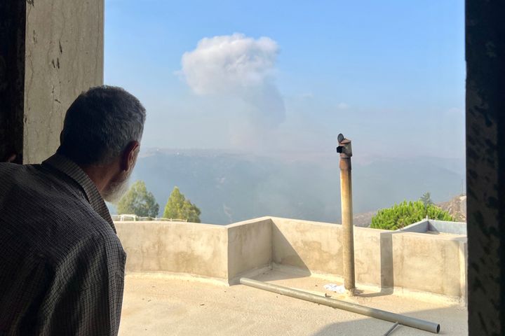 A man watches smoke billow after an Israeli airstrike in the southern Lebanese village of Qsair on August 25, 2024, amid escalations in the ongoing cross-border tensions as fighting continues between Israel and Hamas militants in the Gaza Strip. (Photo by AFP) (Photo by -/AFP via Getty Images)