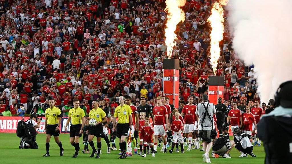 Liverpool and Manchester United players walk out onto the pitch for their friendly match