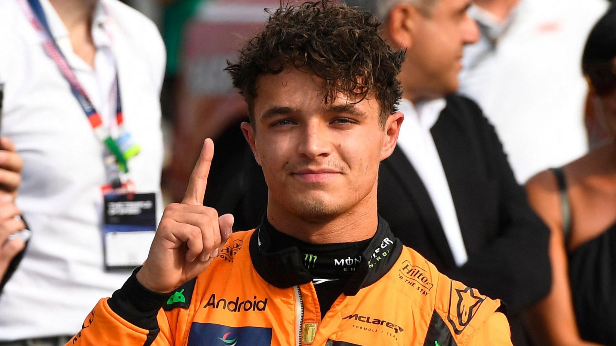 Lando Norris puts up a finger to denote his pole position