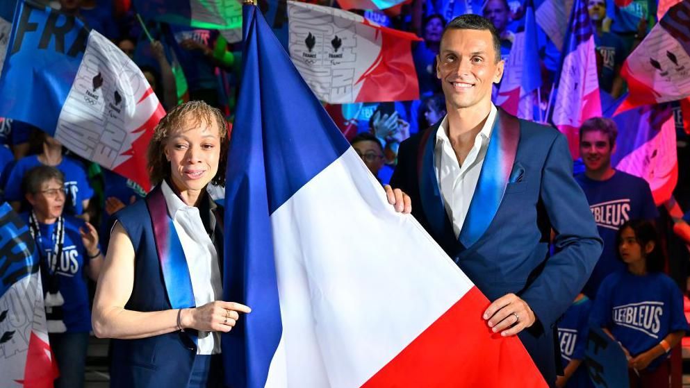 Nantenin Keita and Alexis Hanquinquant pose with the French flag