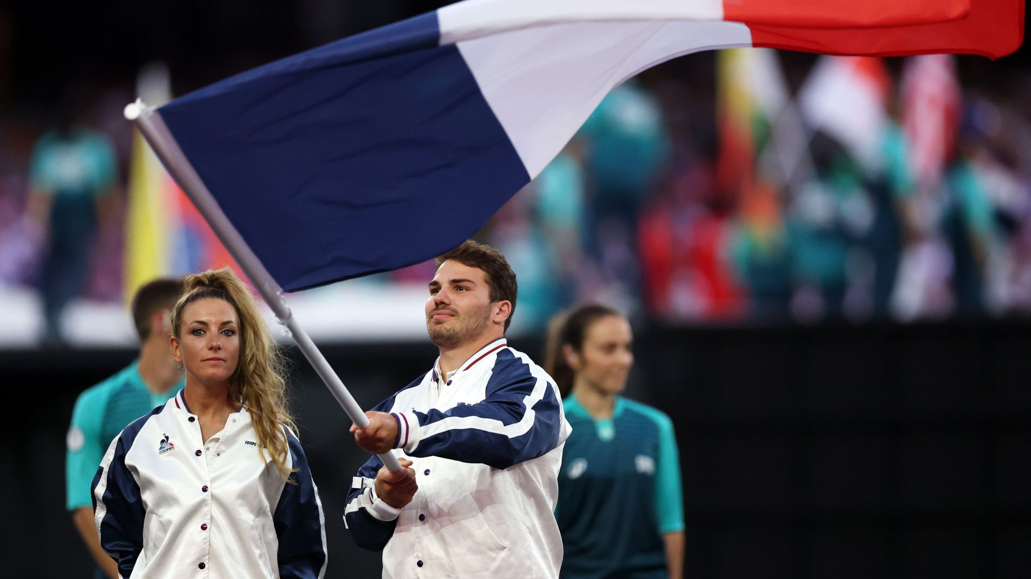 Pauline Ferrand Prevot and Antoine Dupont hold the France flag