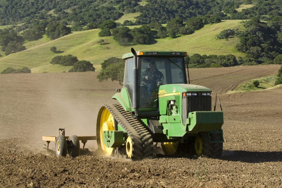 Agriculture - A John Deere tracked tractor and field implement till a new field that will be planted in organic vegetable crops/near Salinas, Monterey County, California, USA. (Photo by: Ed Young/Design Pics Editorial/Universal Images Group via Getty Images)