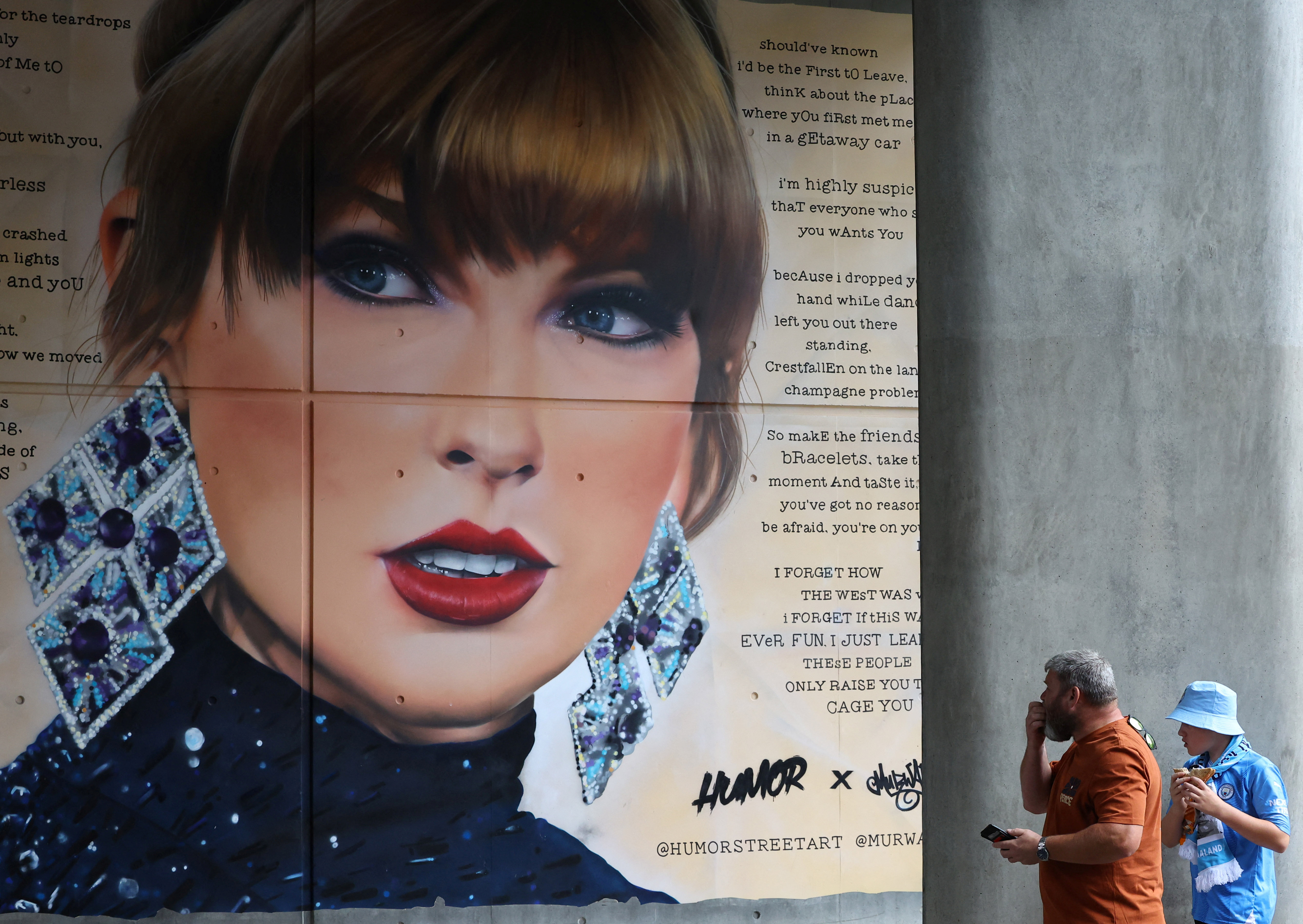 © Reuters. People view a mural of Taylor Swift painted next to Wembley Stadium as they attend the Community Shield football match, ahead of Swift’s first live performance since her concerts in Vienna were cancelled after a security threat was uncovered, in Wembley, London, Britain, August 10, 2024. REUTERS/Toby Melville/File Photo