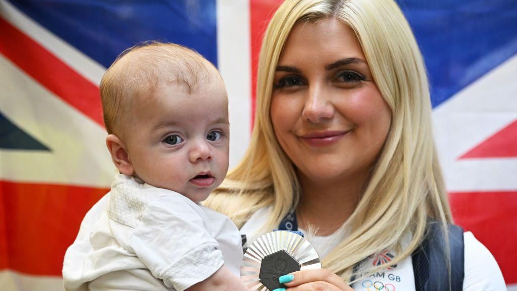 Amber Rutter holding her son Tommy and silver medal