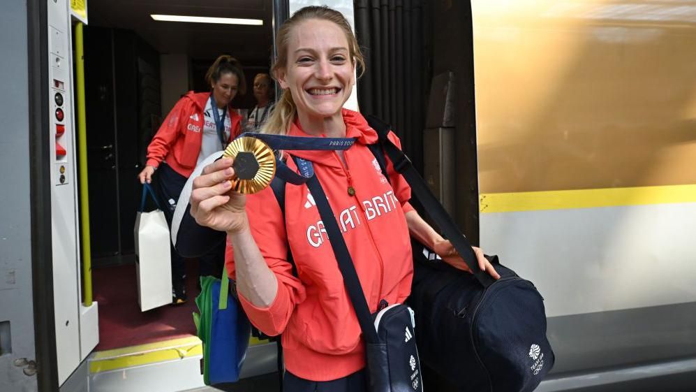  Bryony Page holding up her gold medal while getting off the Eurostar