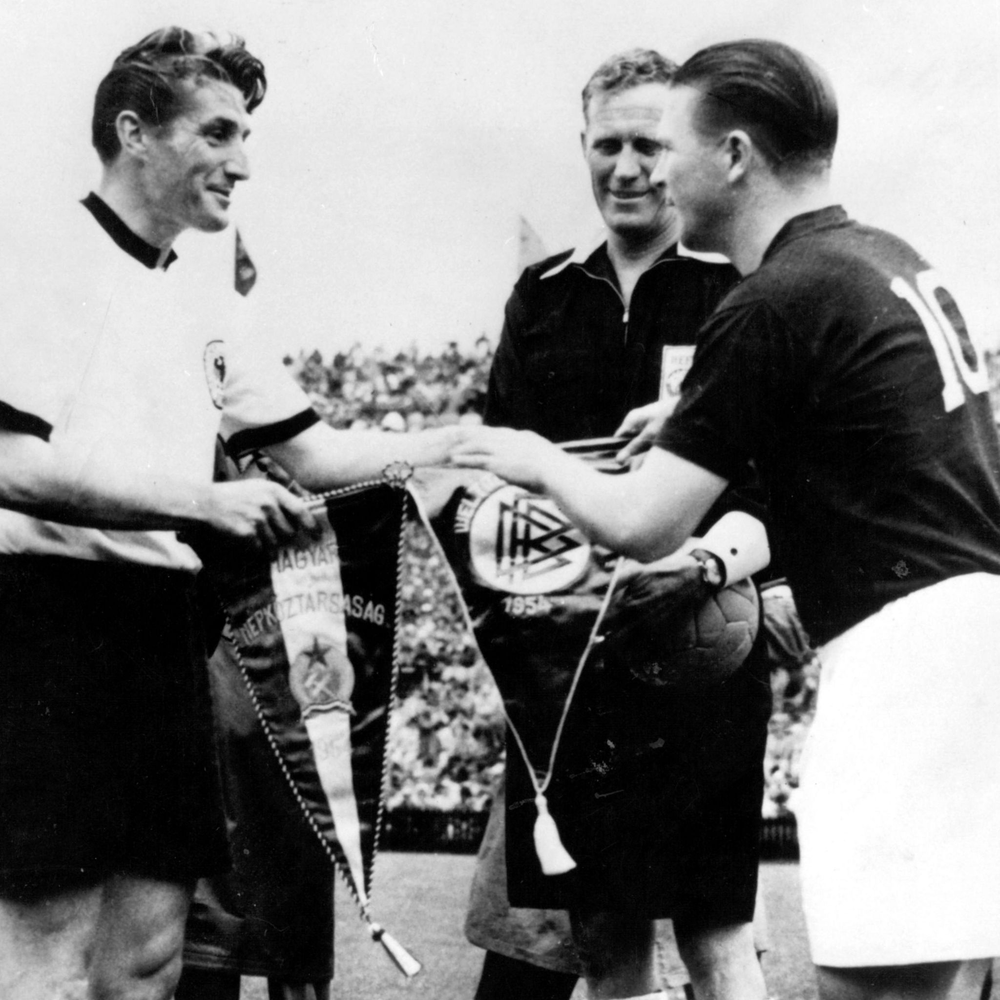 Hungary captain Ferenc Puskas (right) swaps pennants with West German counterpart Fritz Walter before the 1954 World Cup final