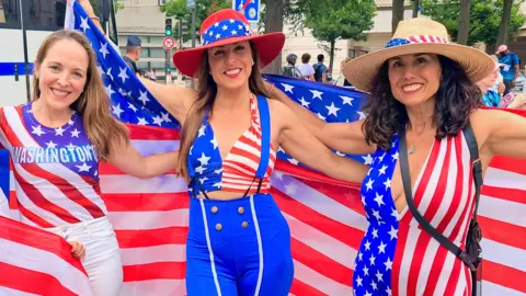 BBC Marisa and two other women, adorned in US regalia, pose for a photo