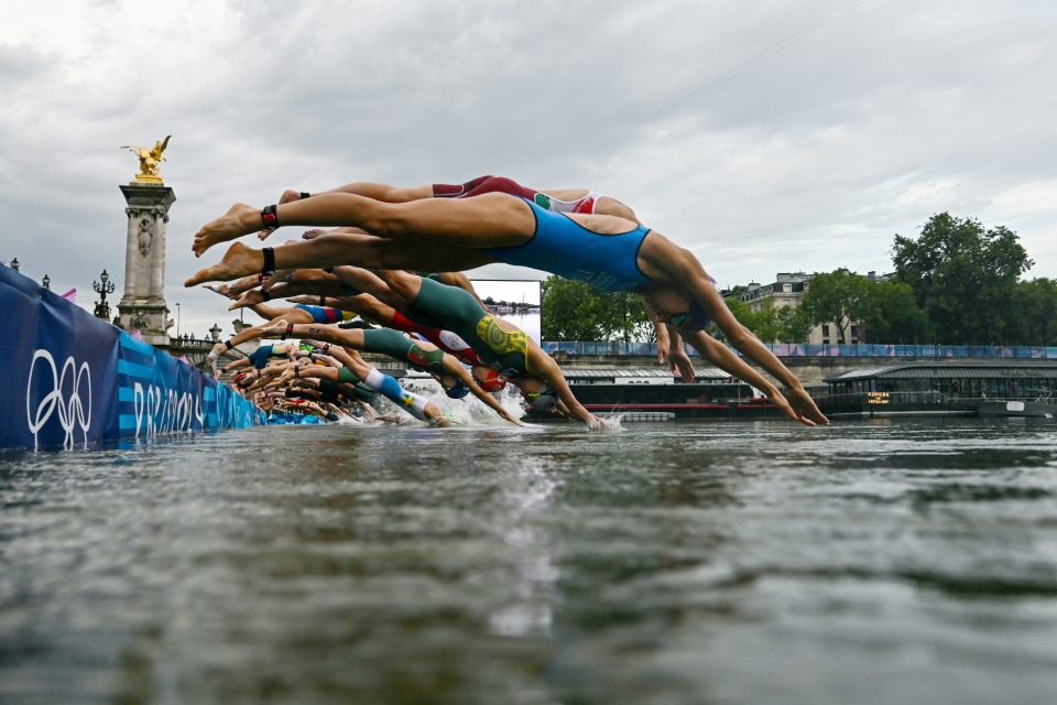 PARIS, FRANCE - JULY 31: Athletes compete in the swimming race in the Seine during the women's individual triathlon at the Paris 2024 Olympic Games at Pont Alexandre III on July 31, 2024 in Paris, France. (Photo by Martin Bureau - Pool/Getty Images)