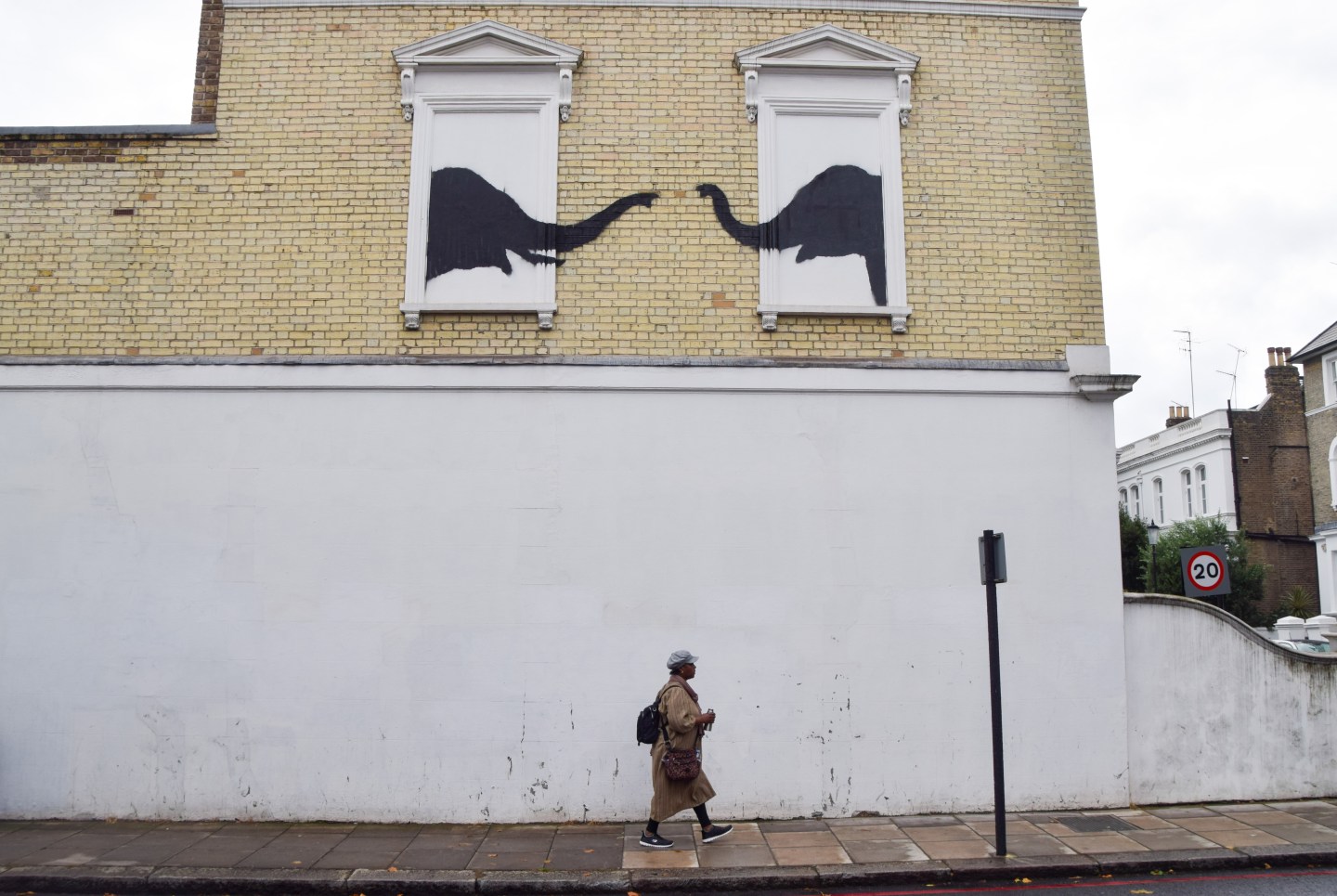 Silhouettes of two elephants spray painted onto boarded up windows