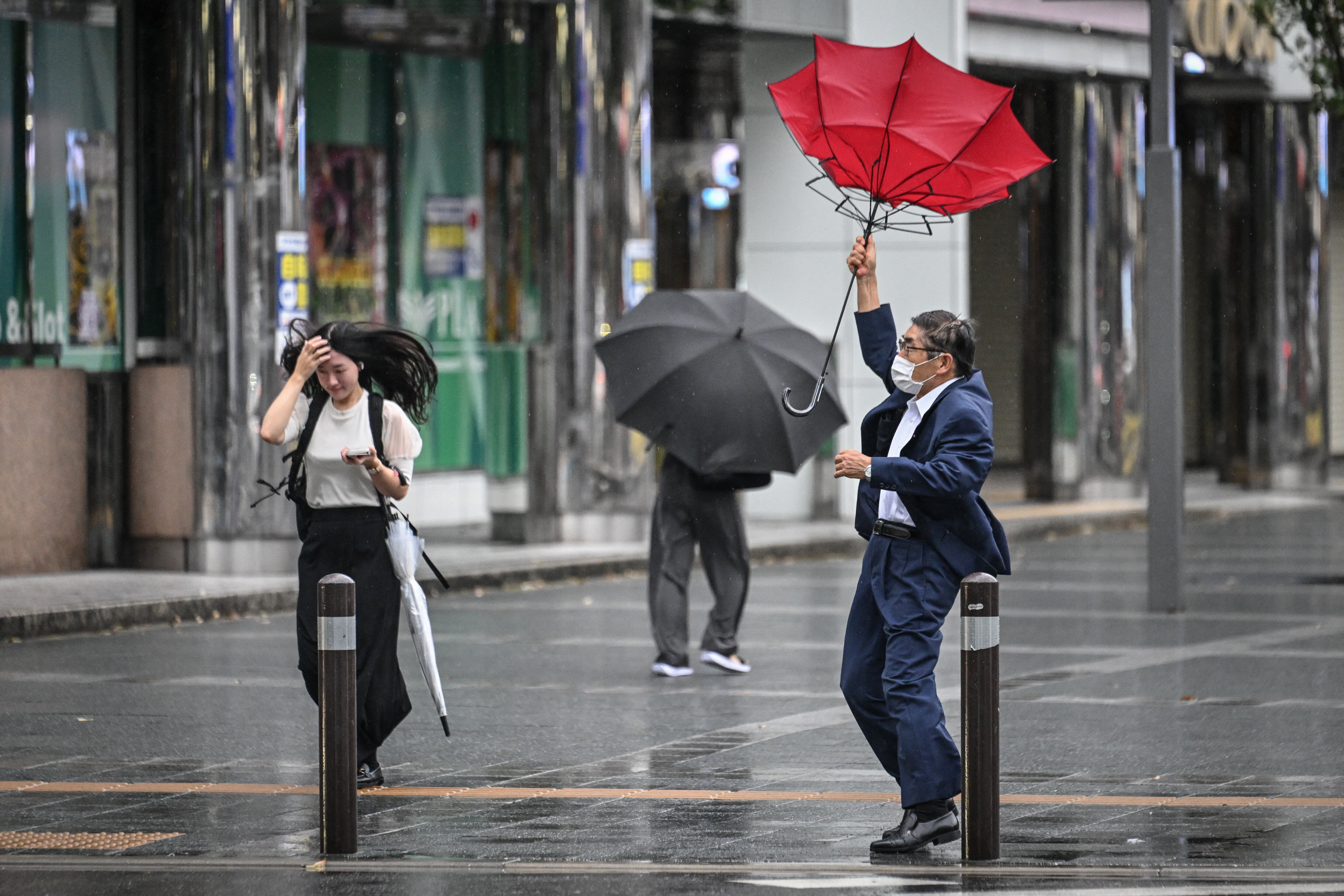 A man holds his umbrella in the wind outside Hakata station in Fukuoka, Japan, on Aug. 29, 2024. 