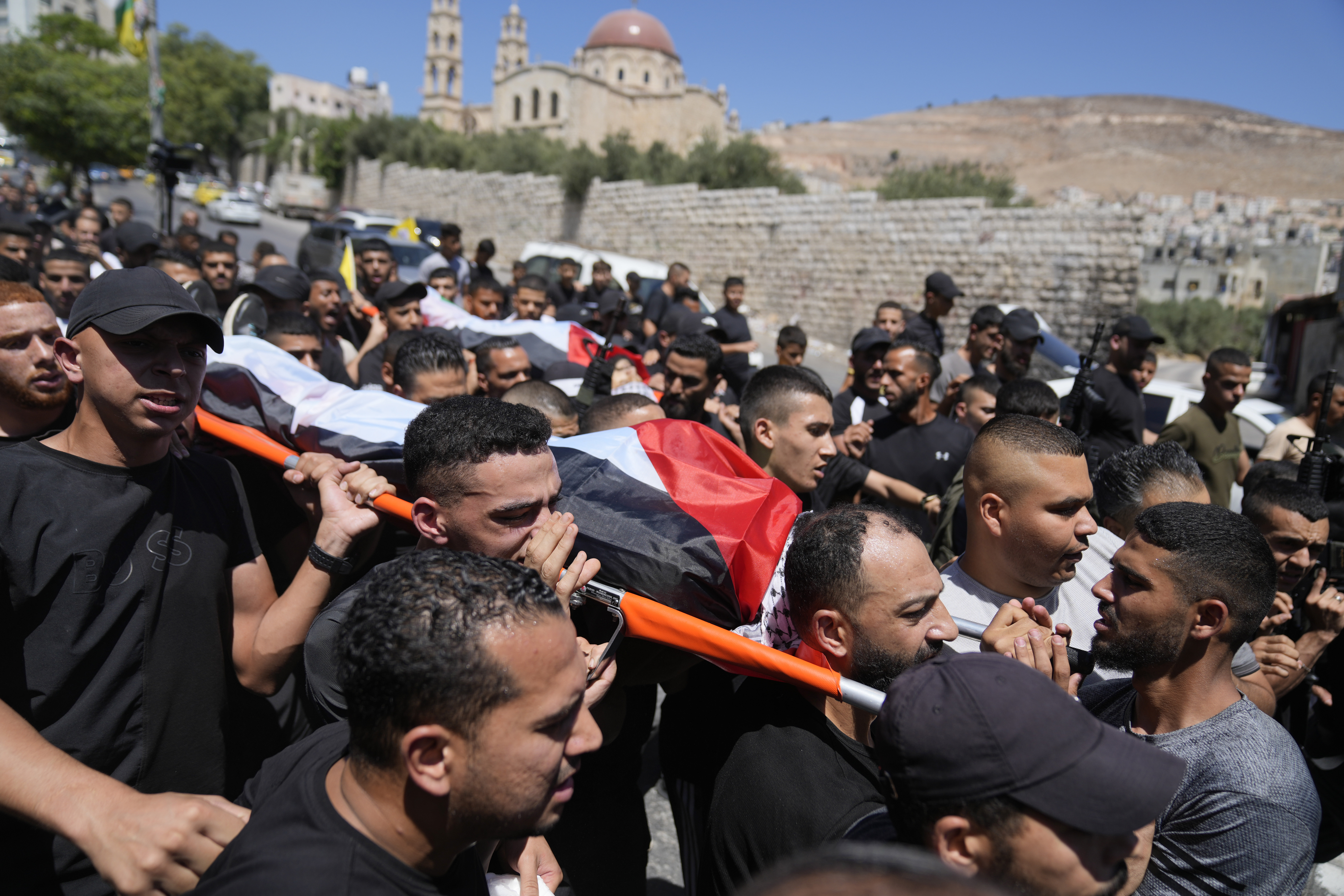 Mourners carry the bodies of Palestinians Wael Misha, 18, front, and Ahmed Sheikh Khalil, 20, both killed by an airstrike overnight during an army operation in the occupied West Bank, during their funeral in the refugee Camp of Balata, in Nablus, on Aug. 15, 2024. 