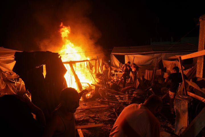 Palestinians react to fire from an Israeli strike that hit tents in the courtyard of Al-Aqsa Martyrs Hospital in Deir al-Balah, Gaza Strip, on Sunday, Aug. 4, 2024.