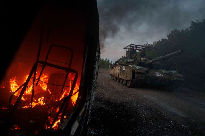 A Ukrainian tank passes by a burning car near the Russian-Ukrainian border, Sumy region, Ukraine, on Aug. 14, 2024.