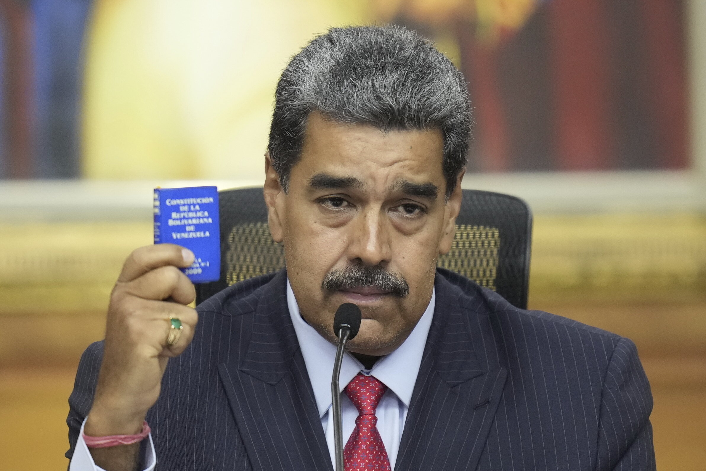 Venezuelan President Nicolas Maduro holds a small copy of the constitution as he gives a news conference at Miraflores presidential palace in Caracas, Venezuela, on July 31, 2024, three days after his disputed reelection.