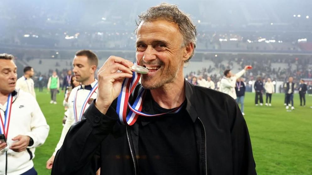 Luis Enrique bites his medal