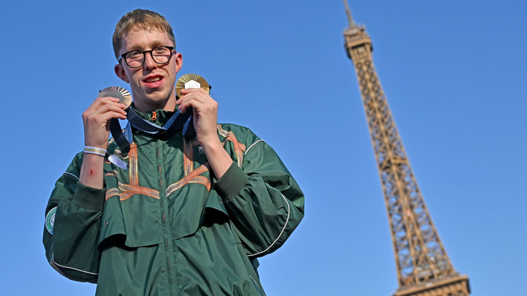 Daniel Wiffen poses with his medals in front of the Eiffel Tower