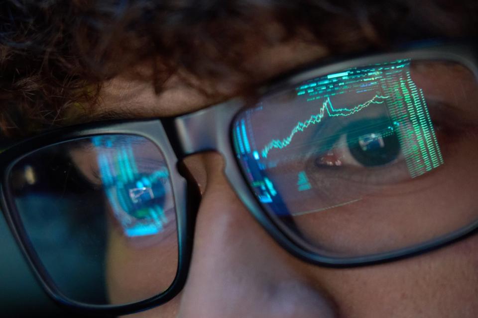 The reflection of a stock chart in a person's eyeglasses.