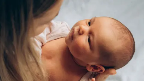 Getty Images Mother holding a newborn baby and looking into the baby's eyes