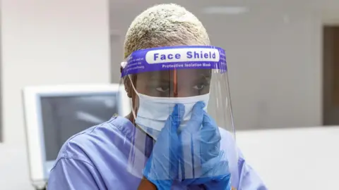 Getty Images Stock picture of healthcare worker wearing a surgical mask and face shield during the pandemic.