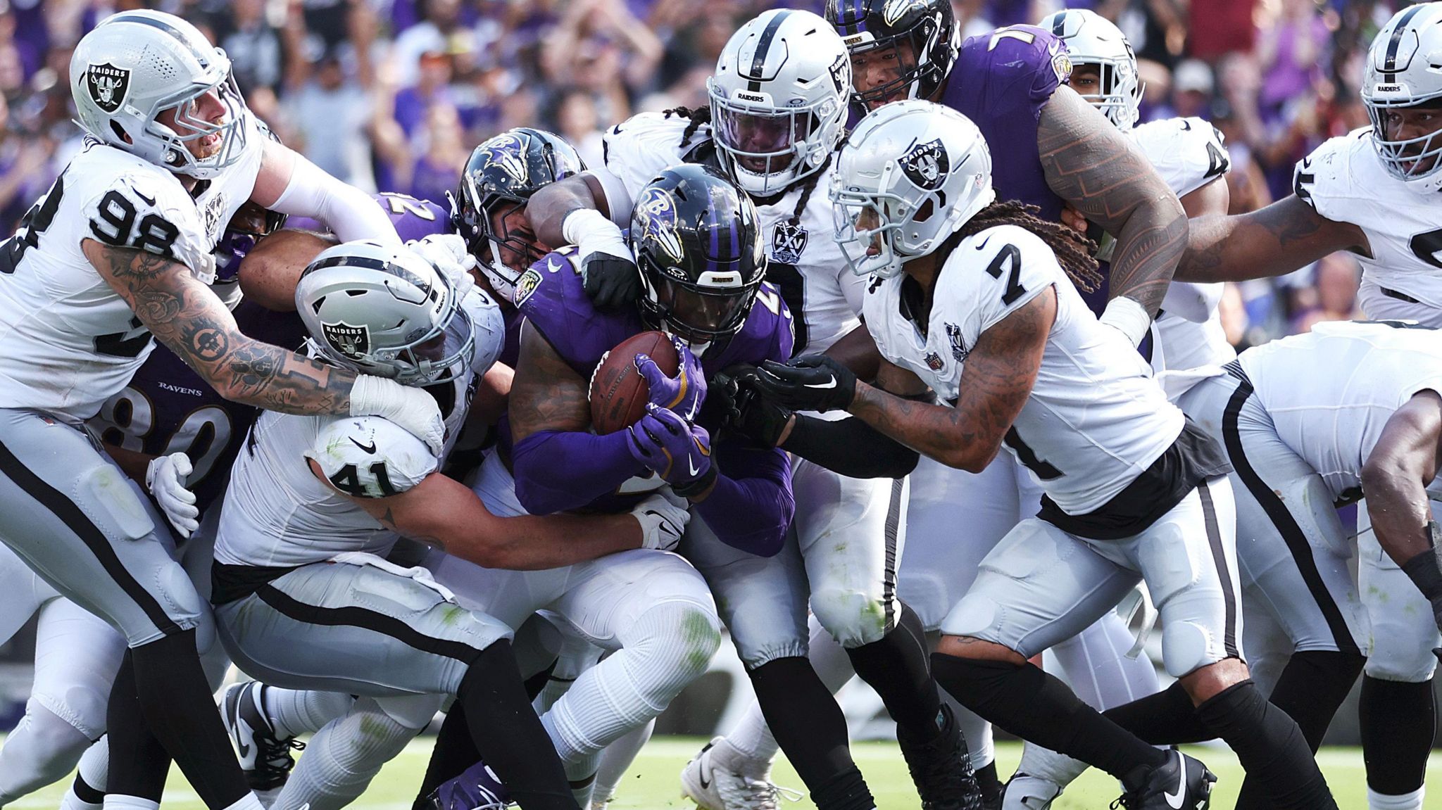 The Las Vegas Raiders defenders swarm around Derrick Henry of the Baltimore Ravens 