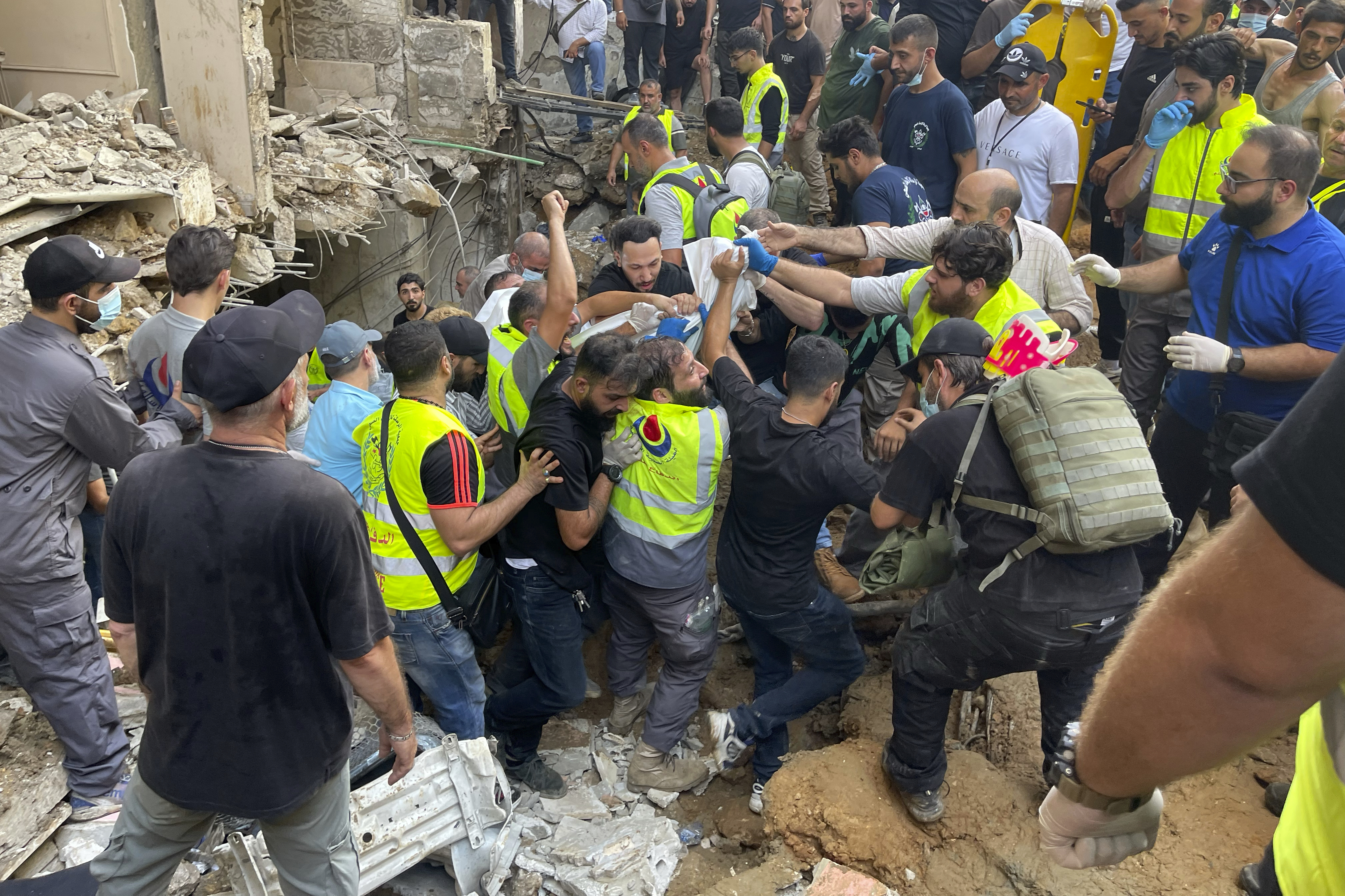 Rescuers carry a body at the scene of a missile strike in the southern suburbs of Beirut, Friday, Sept. 20, 2024. (AP Photo/Bilal Hussein)