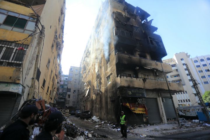 A municipal worker stands next to a damaged building in the aftermath of an overnight Israeli strike in Beirut's southern suburbs on September 29, 2024. Israel said on September 29 that it was carrying out new air raids against "dozens" of Hezbollah targets in Lebanon, after killing the Iran-backed group's leader, Hassan Nasrallah. (Photo by AFP) (Photo by -/AFP via Getty Images)