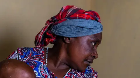 Glody Murhabazi Beatrice Kachera holds a young child in Lwiro hospital, DR Congo