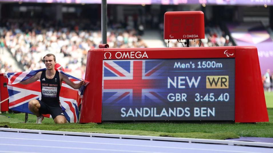 Ben Sandilands celebrates with a Union Flag over his shoulders