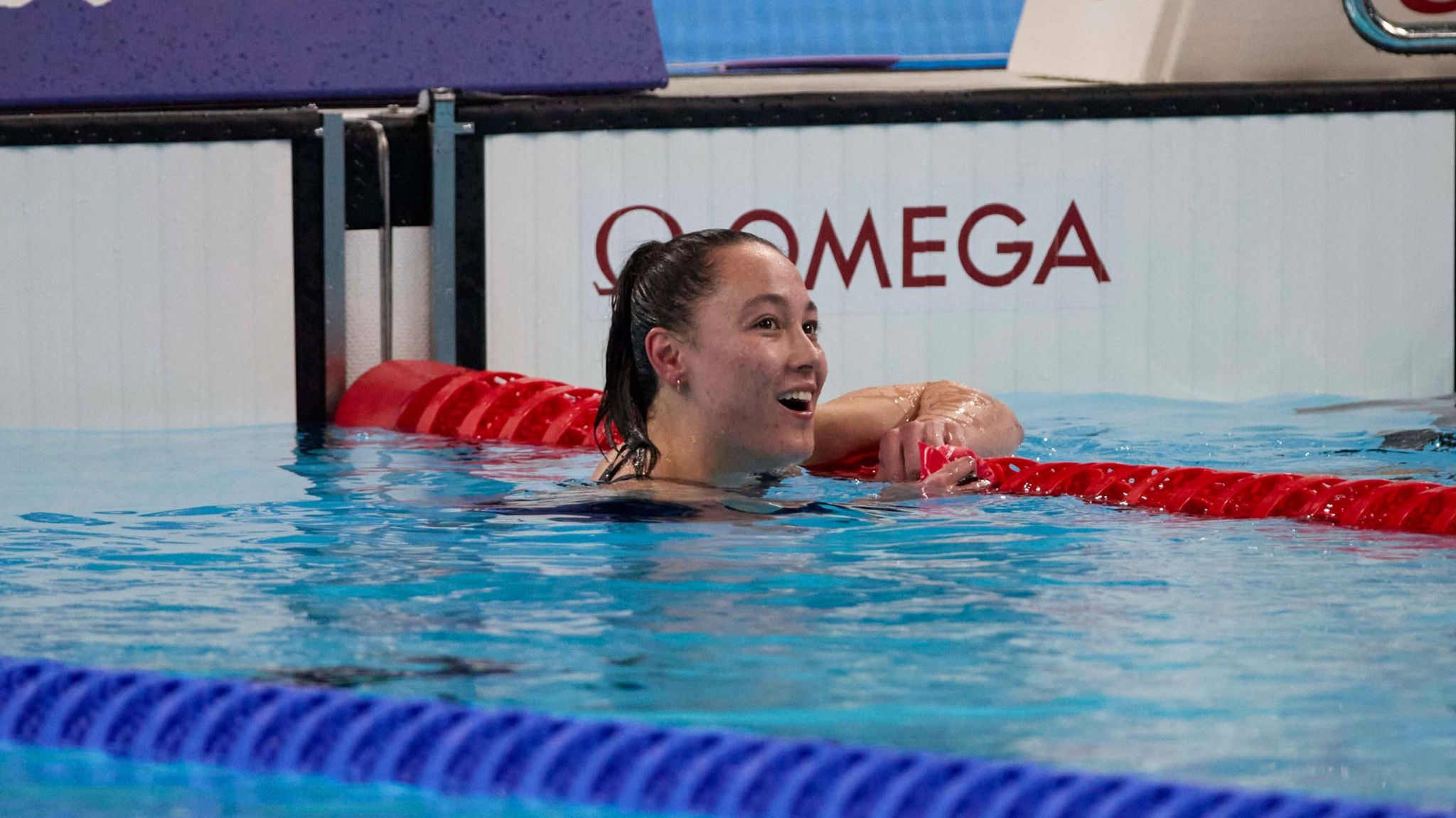 Alice Tai checks the scoreboard after finishing a race in the pool