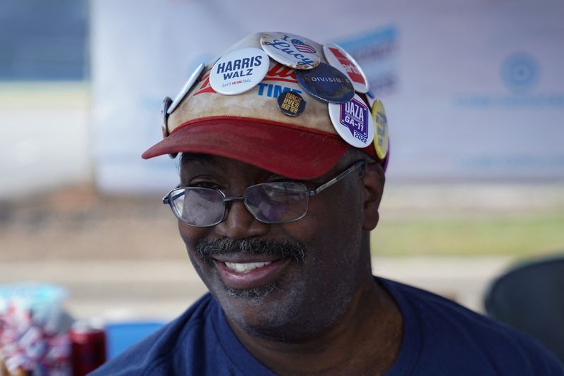 © Reuters. Nathaniel Gray, a volunteer at the Cobb Democrats booth at the Pigs and Peaches country festival in Kennesaw, Georgia, August 17, 2024. REUTERS/Megan Varner