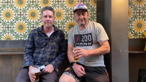 BBC Jack Berman and an unnamed friend hold beers in the smoking section of a pub in Sydney. 30/8/2024