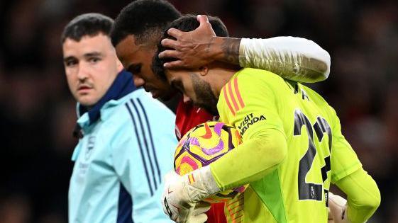 Arsenal defender Gabriel is consoled by team-mate David Raya as he limps off against Liverpool